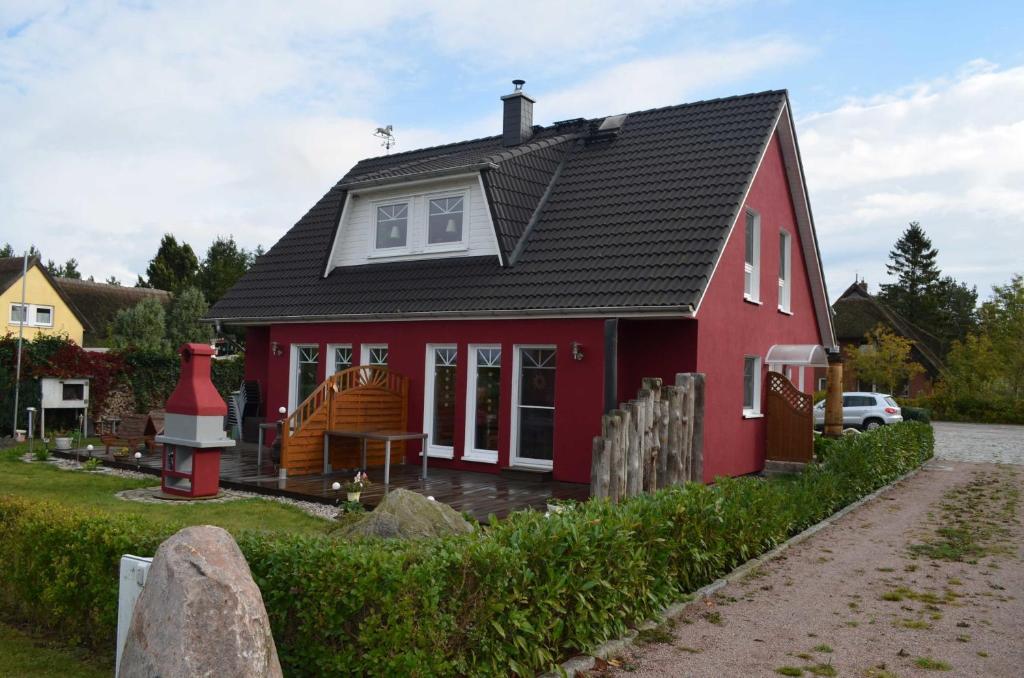 a red house with a black roof at Leuchtfeuer in Born