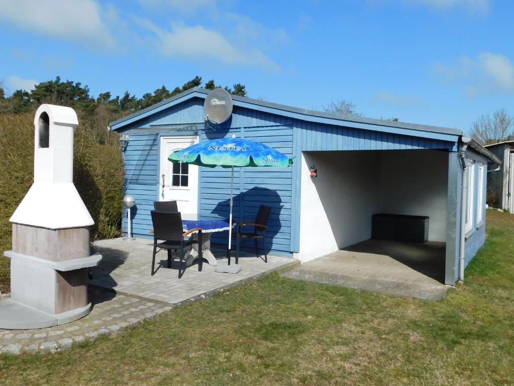 a blue shed with a table and chairs and an umbrella at Haus Krüger in Wieck