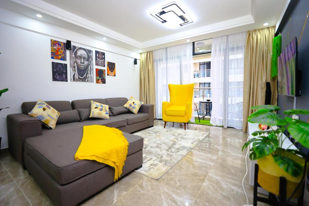 uma sala de estar com um sofá e uma cadeira amarela em Elite Luxury Apartments Kilimani - An Oasis of Serenity and Tranquility em Nairobi