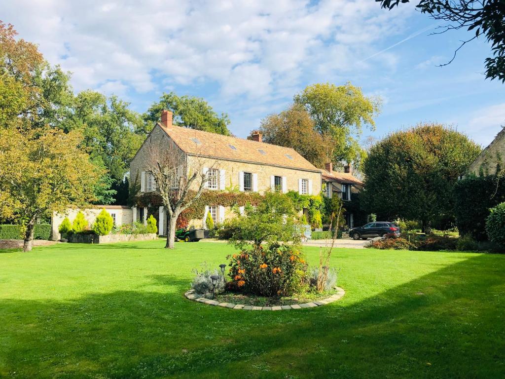 une grande maison avec une cour verdoyante et un jardin fleuri dans l'établissement La plaine de l'Angelus, à Chailly-en-Bière