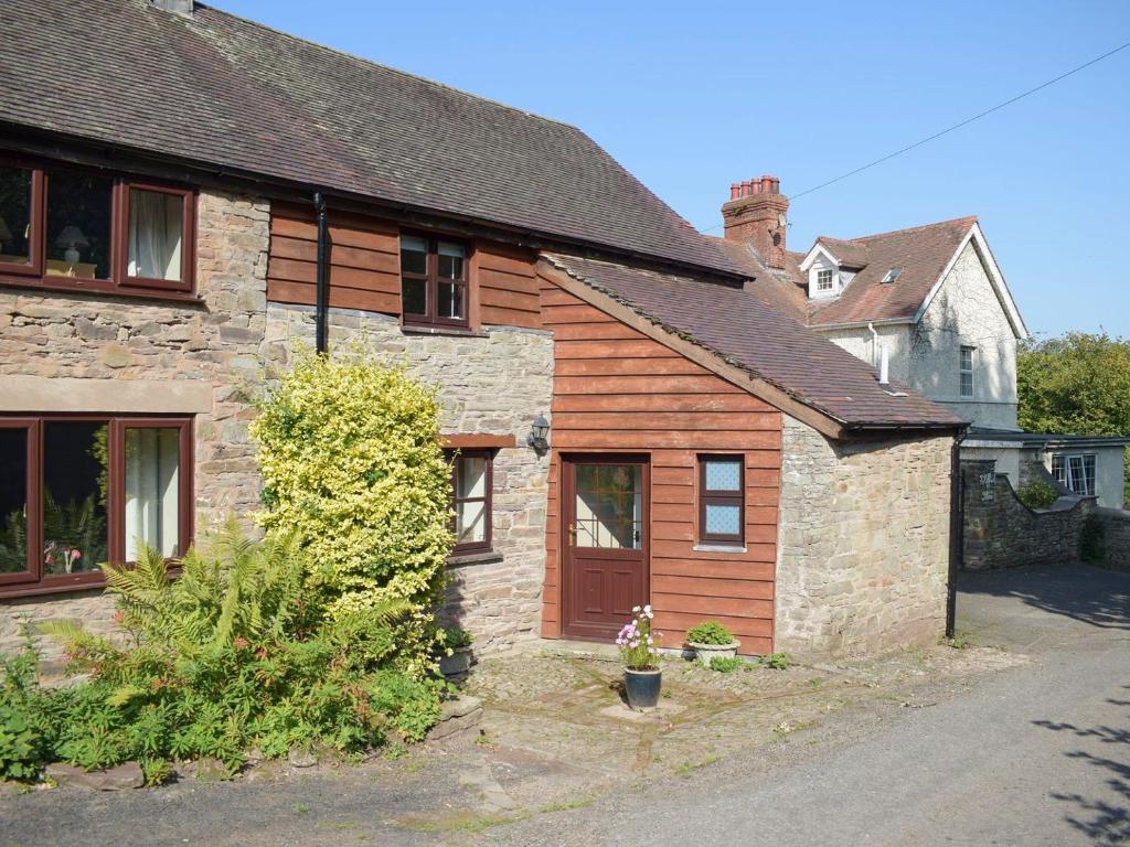 una antigua casa de piedra con una puerta marrón en Easterley Uk31585, en Clifford