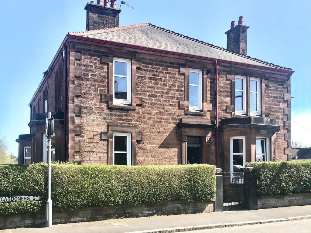 an old brick house with bushes in front of it at Cardoness House in Dumfries