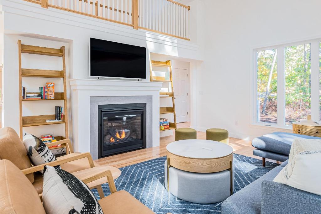 a living room with a fireplace and a tv at Peace Among the Pines in Wellfleet