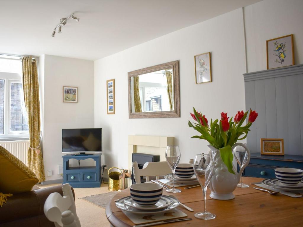 ein Wohnzimmer mit einem Tisch und einer Blumenvase in der Unterkunft Number 3 - Uk33333 in Newby
