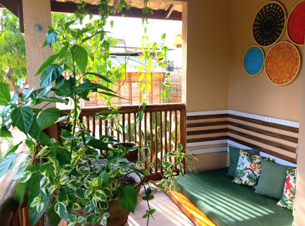 a balcony with a bench and a window with plants at Residencial Villa Jeri - ground floor apartment 300m from the beach in Jericoacoara