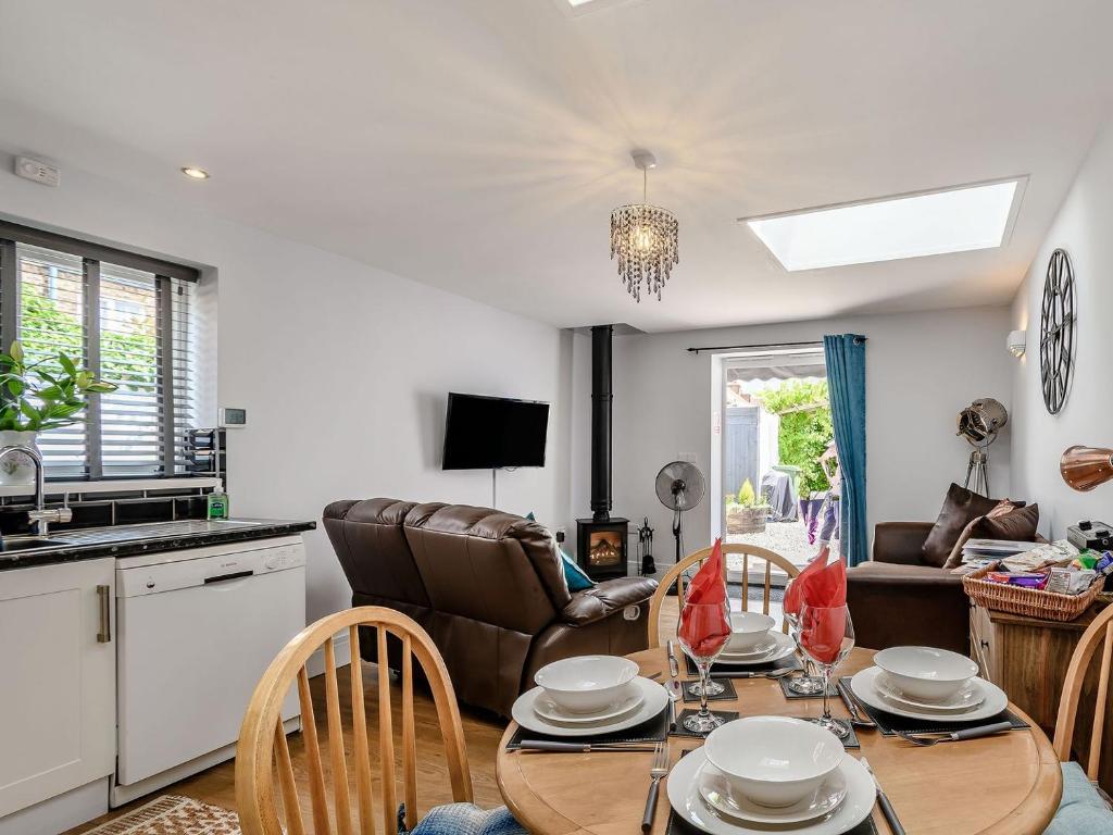 een keuken en een woonkamer met een tafel en stoelen bij Cozy Lodge in Barton upon Humber