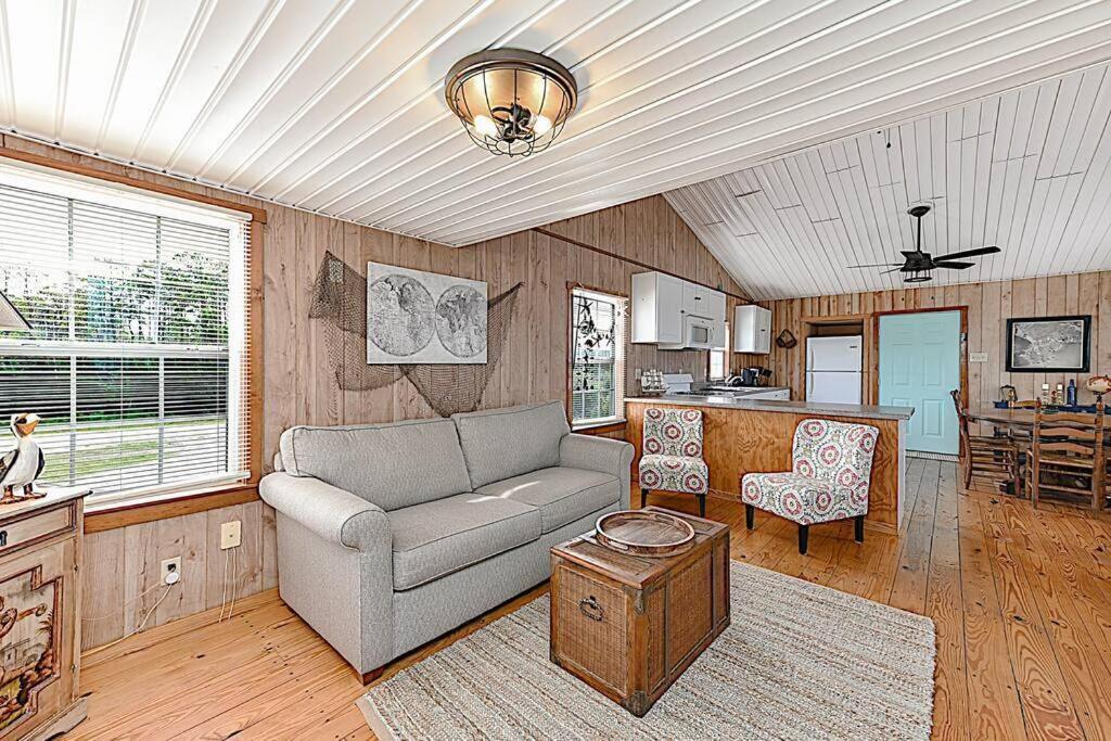 a living room with a couch and a kitchen at Shipwrecked Shack Waterfront House Boat on Land in Sealevel