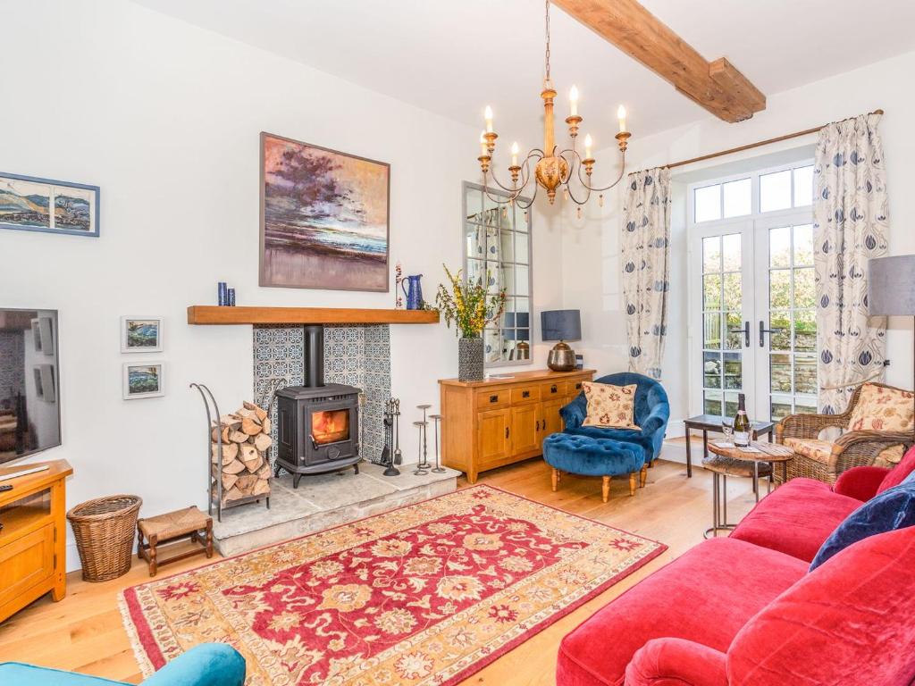 a living room with a red couch and a fireplace at The Farmhouse - Uk33419 in West Witton