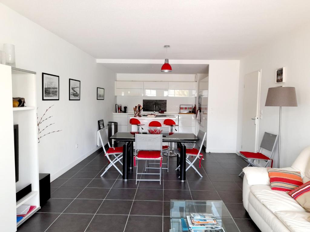 アルカションにあるAppartement Arcachon, 3 pièces, 4 personnes - FR-1-319-11のリビングルーム(黒いテーブル、赤い椅子付)