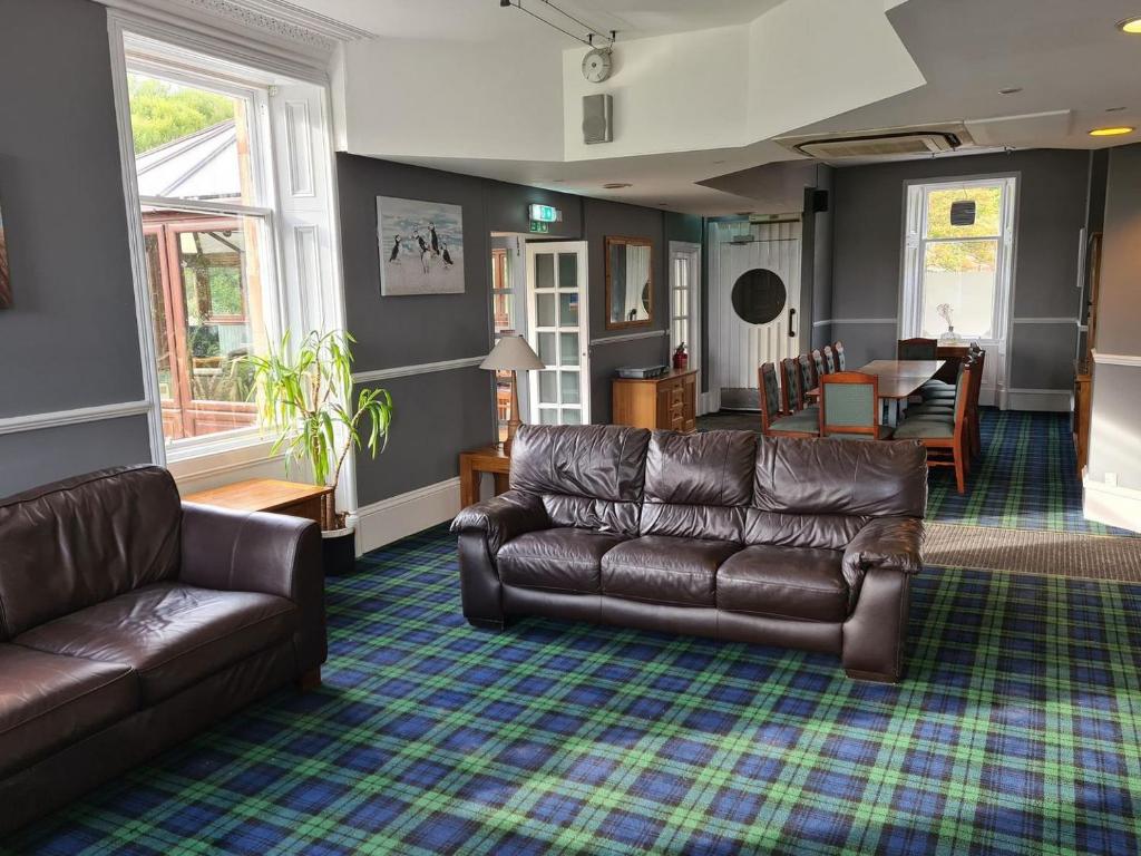 a living room with a leather couch and a table at The Wild Cat - Uk31598 in Avoch