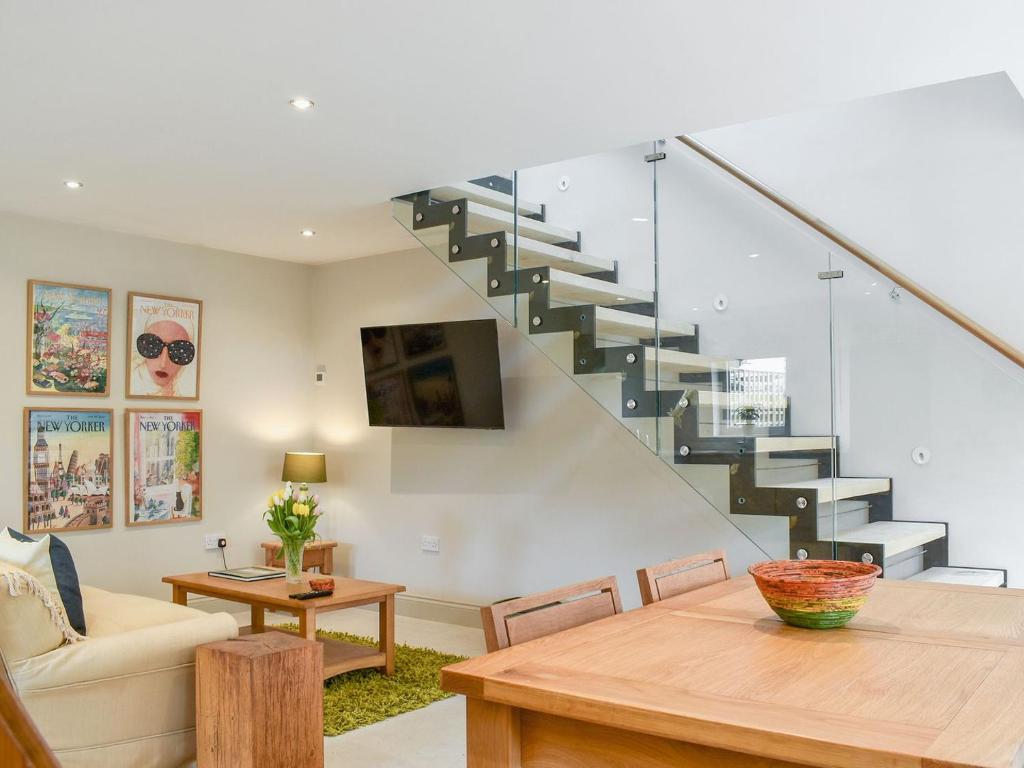 a living room with a staircase and a table at Sika Cottage - Uk36194 in Fordingbridge