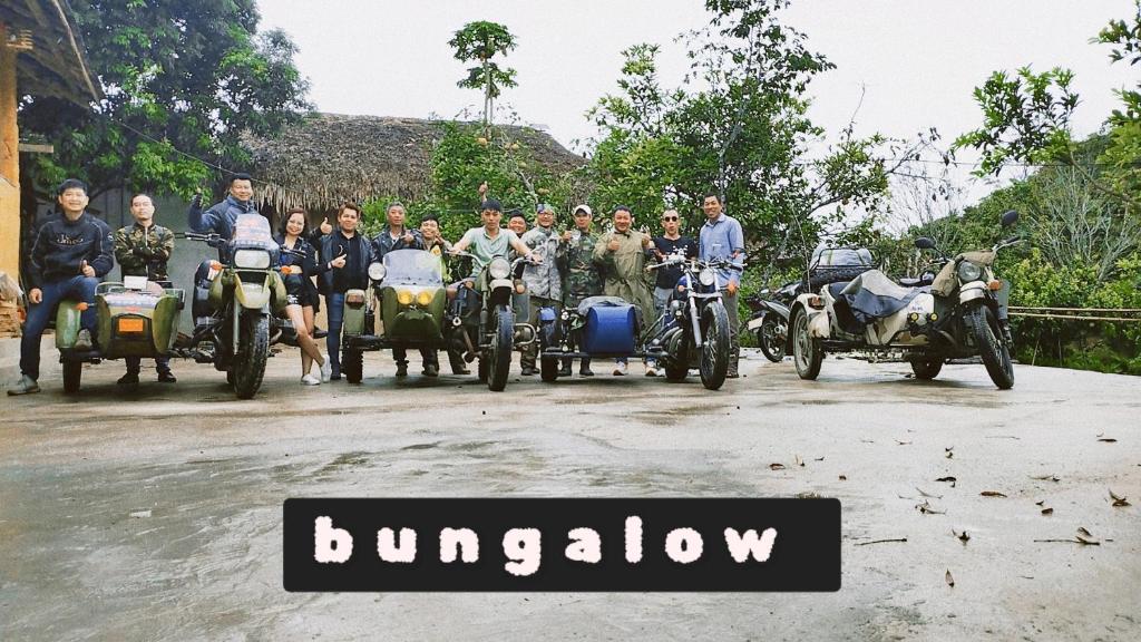 un groupe de personnes se posant pour une photo avec des motocycles dans l'établissement huy homestay, à Ha Giang