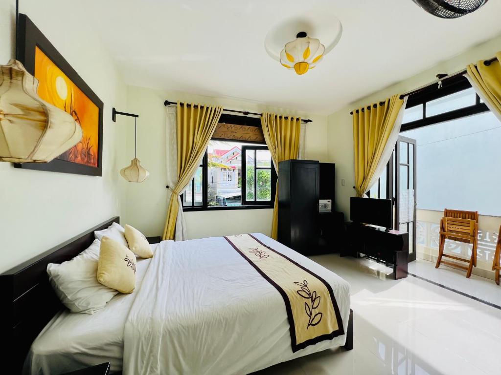 um quarto com uma cama e uma televisão em Hoi An Cottage Villa em Hoi An