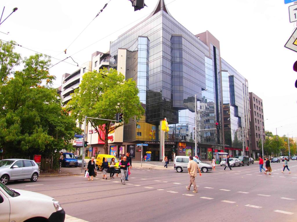 Un gruppo di persone che attraversa una strada in una città di Stay Nexus Galaxy Center a Sofia