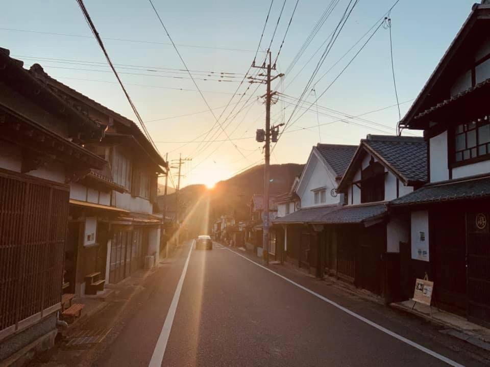 samochód jadący ulicą z zachodem słońca w obiekcie Akitsuki Kominka Ryokan You w mieście Asakura
