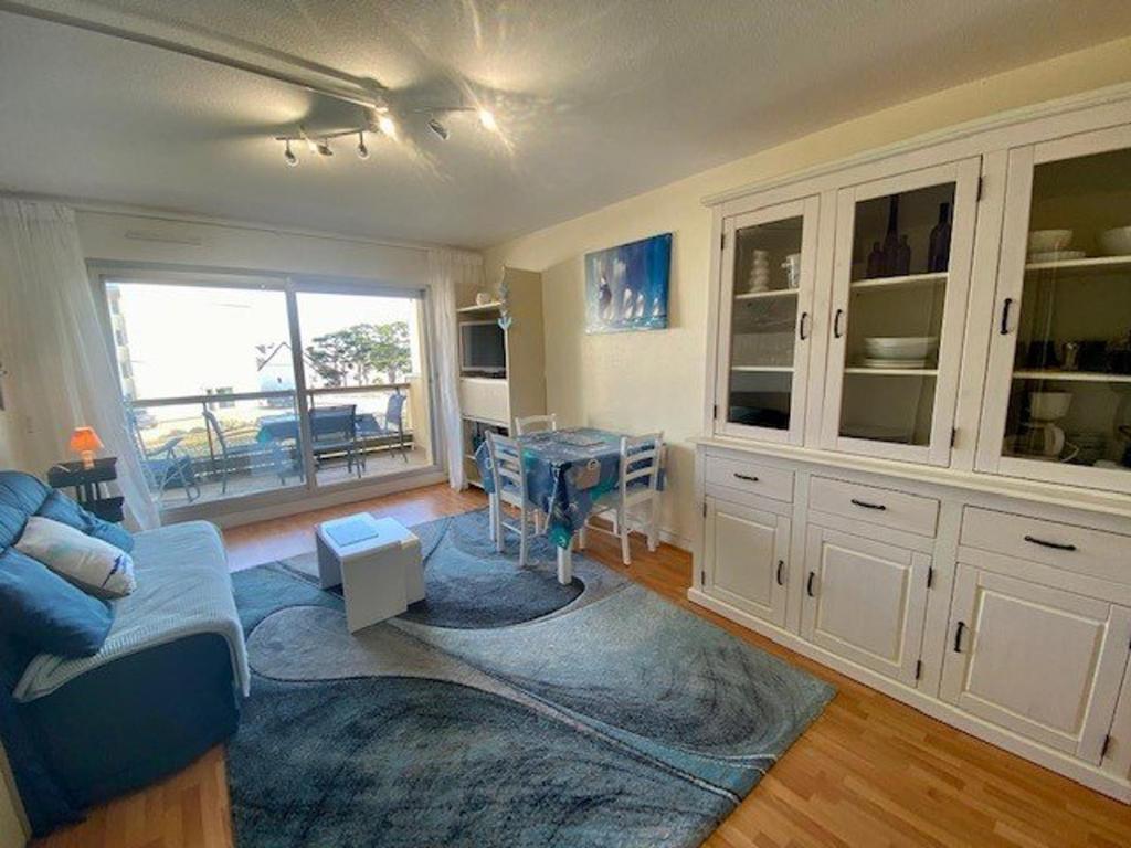 un salon avec un canapé bleu et une table dans l'établissement Studio rénové 29m² à Quiberon avec parking privé - FR-1-478-132, à Quiberon