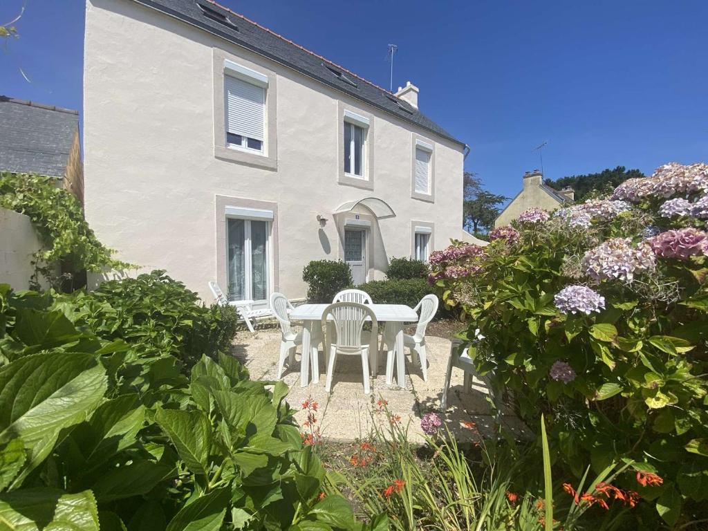 une table et des chaises devant une maison blanche dans l'établissement Appartement avec jardin proche plage et port, 2 chambres, parking privé, équipements complets - FR-1-481-56, à Combrit