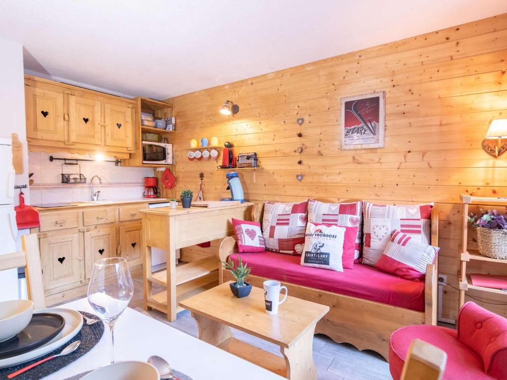 a living room with a red couch in a kitchen at Appartement Saint-Lary-Soulan, 2 pièces, 4 personnes - FR-1-296-331 in Saint-Lary-Soulan