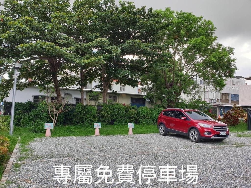 a red car parked in a parking lot at Happiness Homestay in Hualien City