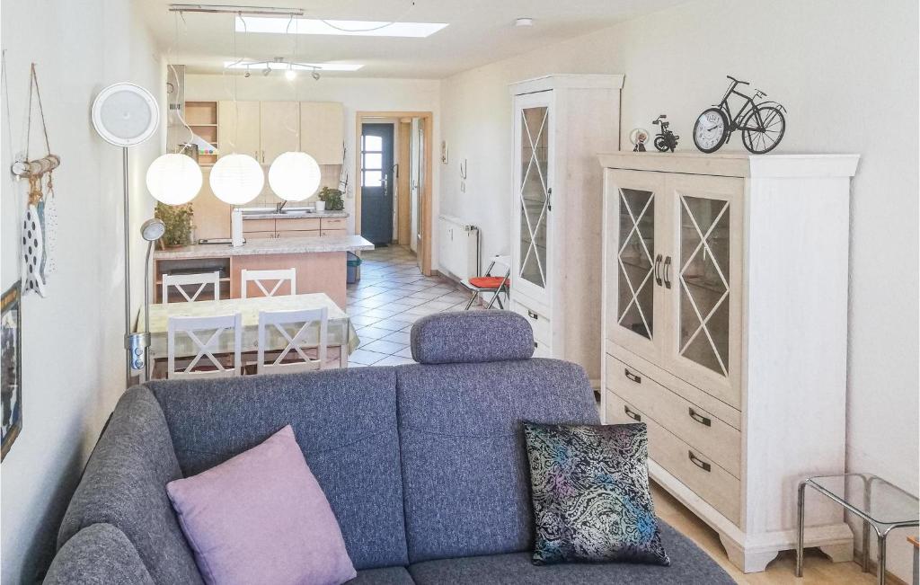 a living room with a blue couch and a kitchen at 1 Bedroom Nice Apartment In Barth in Barth