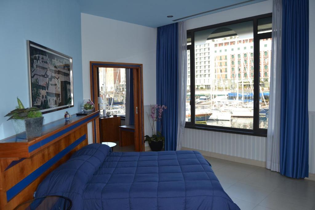 a bedroom with a blue bed and a large window at Transatlantico in Naples