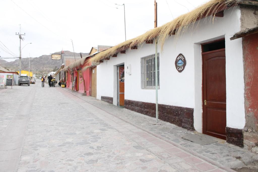 an empty street in a town with buildings at Hostal Cali in Putre