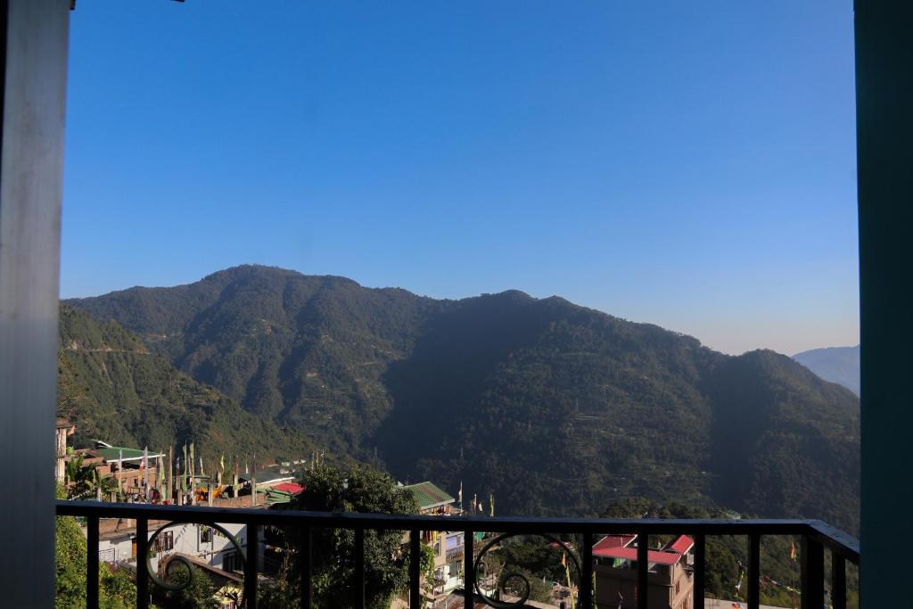 a view of a mountain range from a balcony at SHARTHI HOMESTAY AND LODGING in Namchi