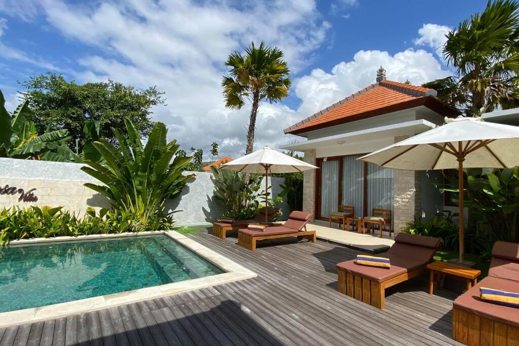 a backyard with a swimming pool and a villa at Nau Nusa Villa in Nusa Penida