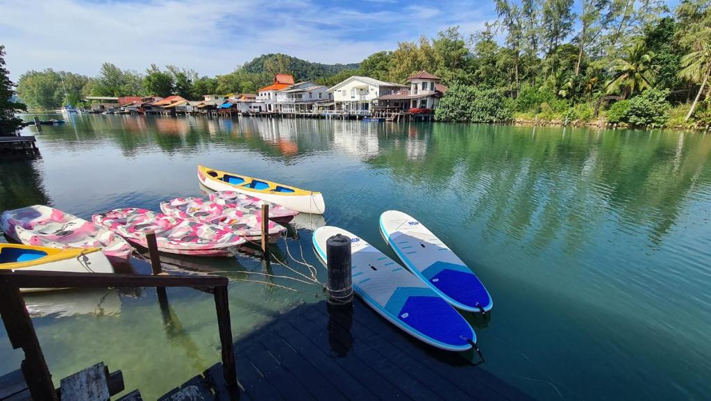 a group ofkayaks sitting on the water at a dock at Baan Rim Nam in Ko Chang