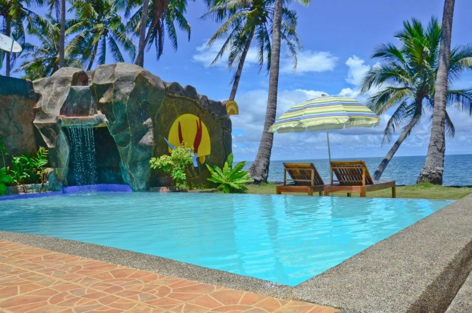 a pool at the resort with a rock waterfall at Crystal Paradise Resort Spa & Winery in Narra