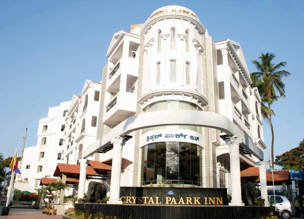 a large white building with aavyigil park inn at Crystal Paark Inn By Blu Orchid Group in Mysore