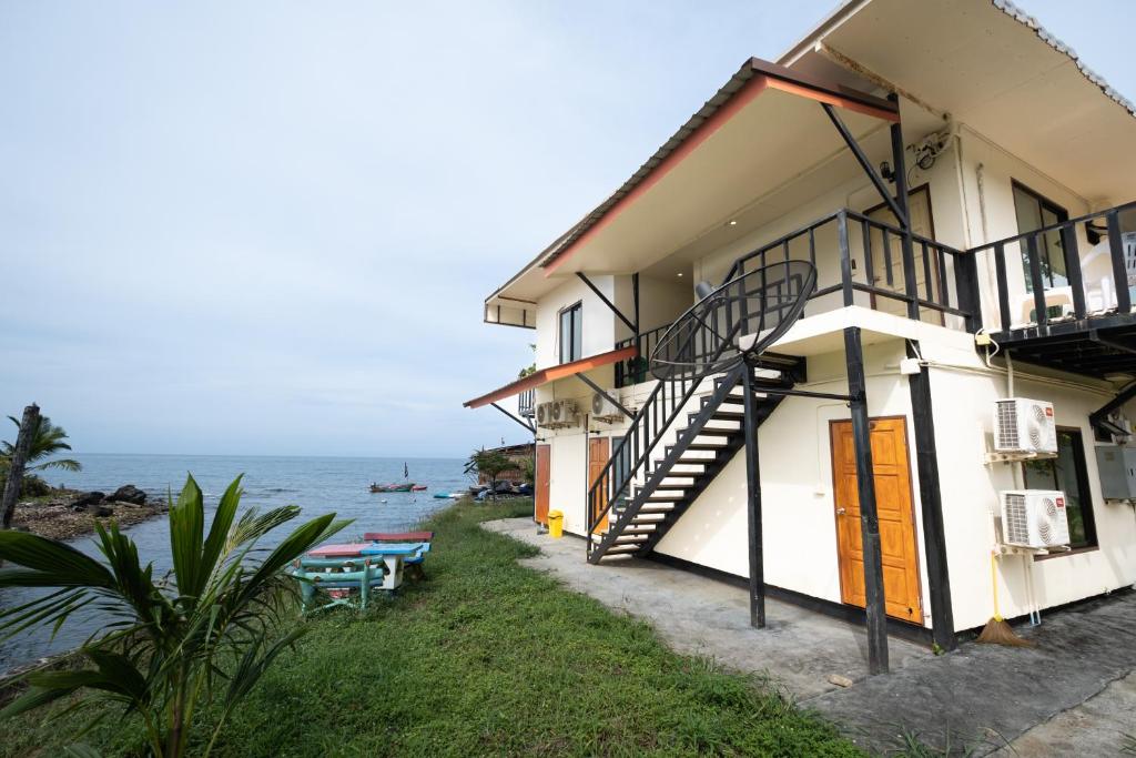 a building with stairs next to the ocean at Mimo Guesthouse in Ko Chang