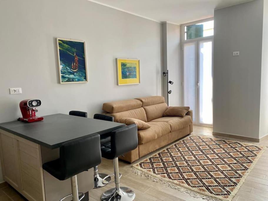 ein Wohnzimmer mit einem Tisch und einem Sofa in der Unterkunft Appartamento centralissimo in Piazza Bresca in Sanremo