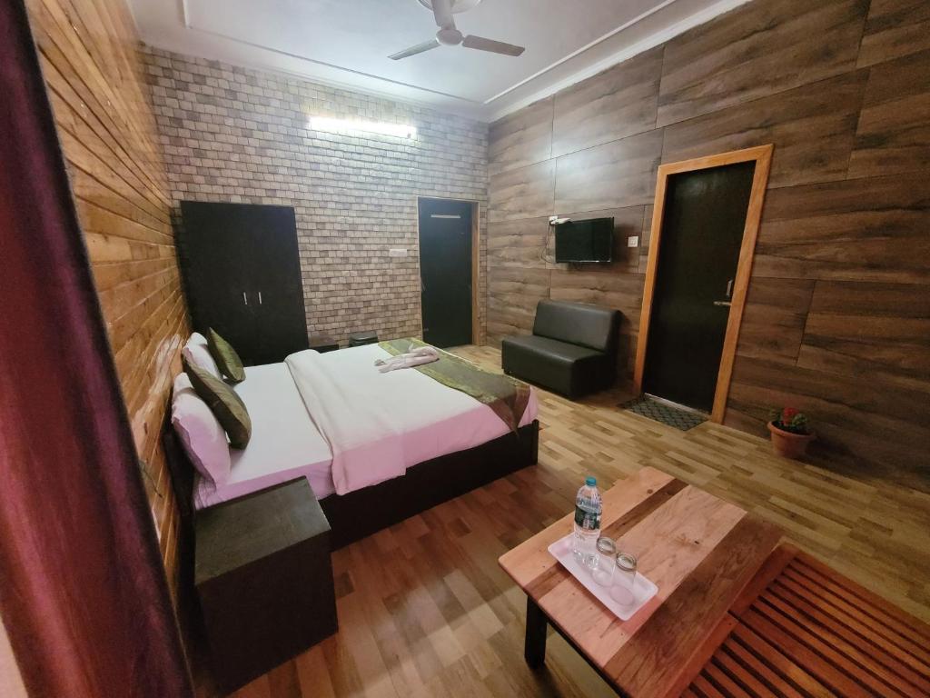 una camera con letto, tavolo e divano di SH SUNSET RESORT a Nainital