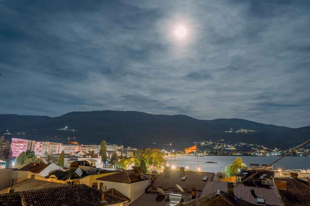 una vista de una ciudad por la noche con la luna en Darija Apartments - City Square, en Ohrid