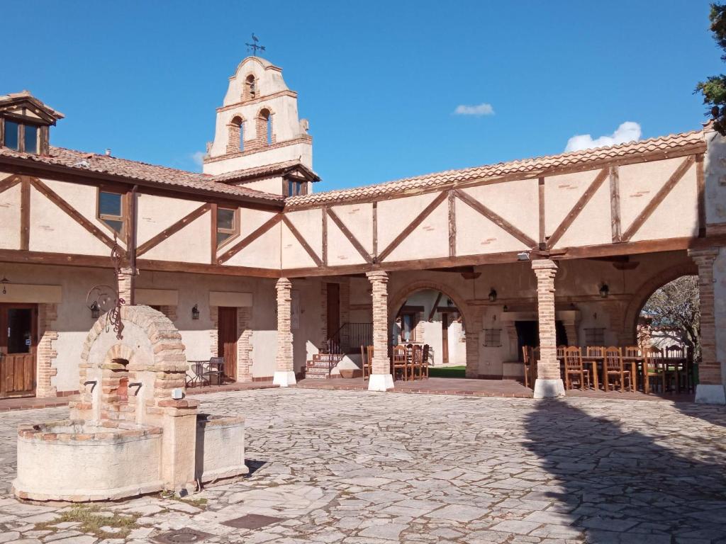 a building with a statue in the middle of a courtyard at La Cerca Entre Hoces-10-20pax-Amplios espacios comunes in Sebúlcor