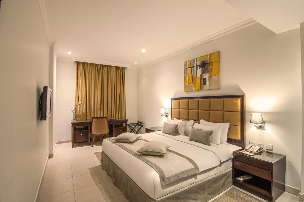 A bed or beds in a room at Corp Executive Hotel Doha Suites