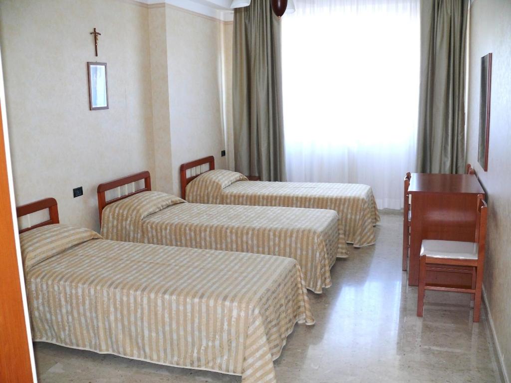 Postel nebo postele na pokoji v ubytování Albergo Casa Del Pellegrino