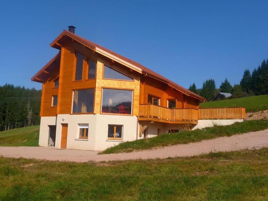 Grand Valtin : chalet écolo 4 étoiles 14 personnes في Ban-sur-Meurthe-Clefcy: منزل خشبي كبير على قمة تلة