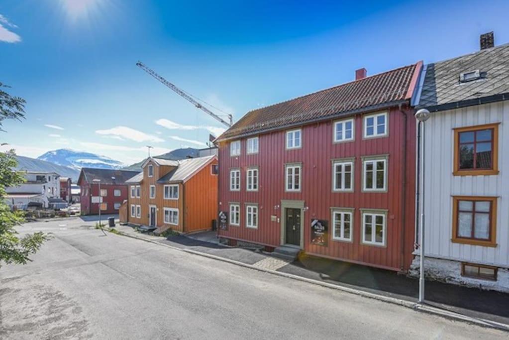 a row of red and white houses on a street at Cosy 2-rooms apartment in the city center in Tromsø