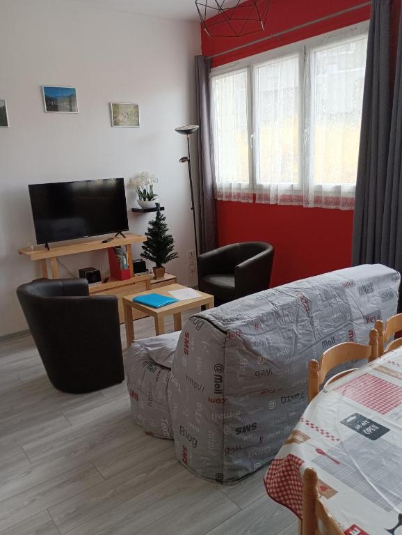 un salon avec un canapé et une table avec une télévision dans l'établissement LA VOLIERE des PICS, à Le Mont-Dore