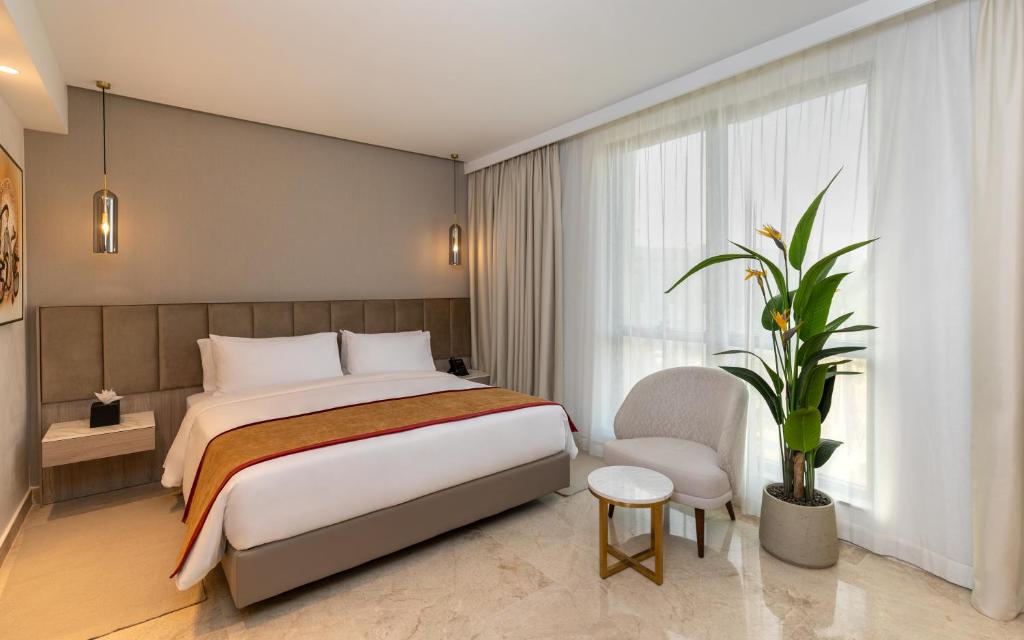 a bedroom with a bed and a large window at Hotel Royal ASBU Tunis in Tunis