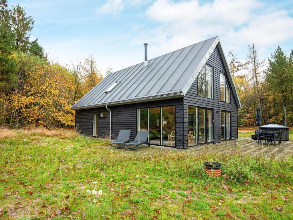 a black cabin with a pitched roof at Holiday home Hovborg VIII in Hovborg