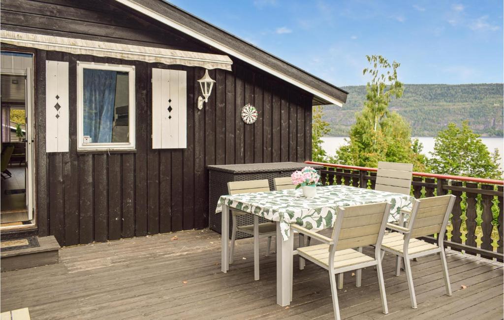 a table and chairs on the deck of a house at Amazing Home In Vikersund With Jacuzzi And 4 Bedrooms in Vikersund