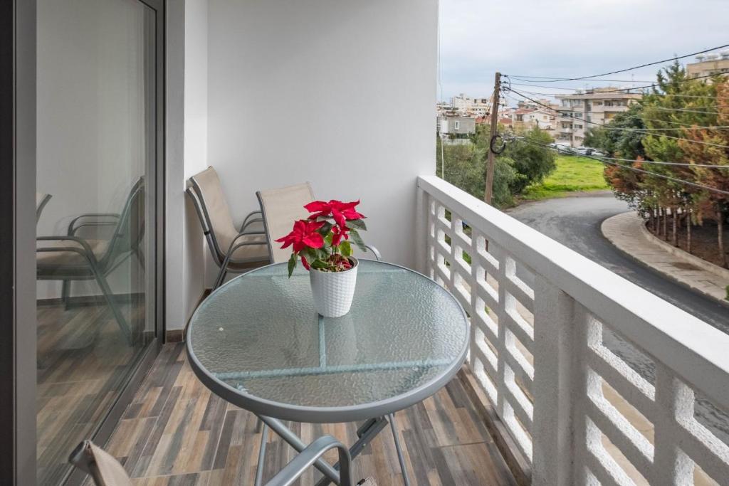 una mesa de cristal con una flor roja en el balcón en Happy Stay Apartment - Halefka Court en Lárnaca