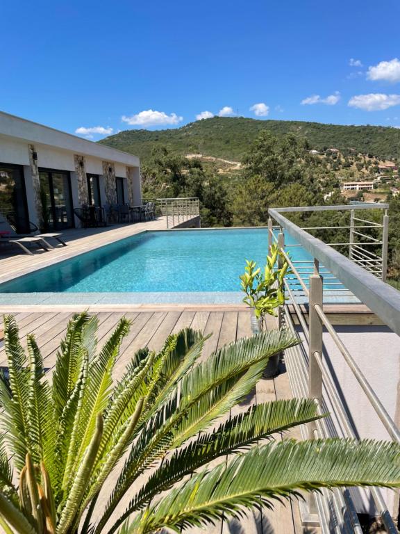 - une vue sur la piscine depuis le balcon d'une maison dans l'établissement Villa neuve avec grande piscine chauffée vue mer, à Conca