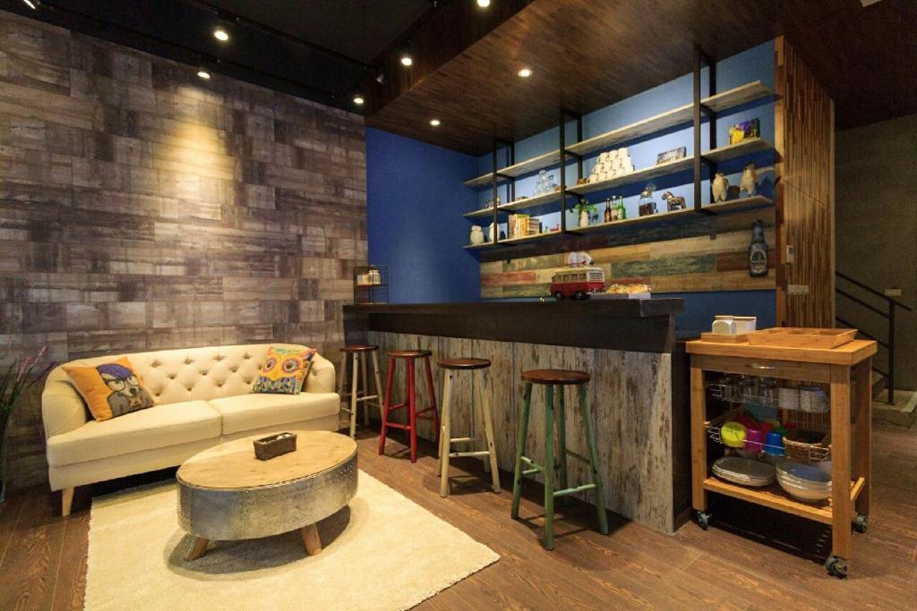 a living room with a couch and a bar with stools at Book 5 in Dongshan