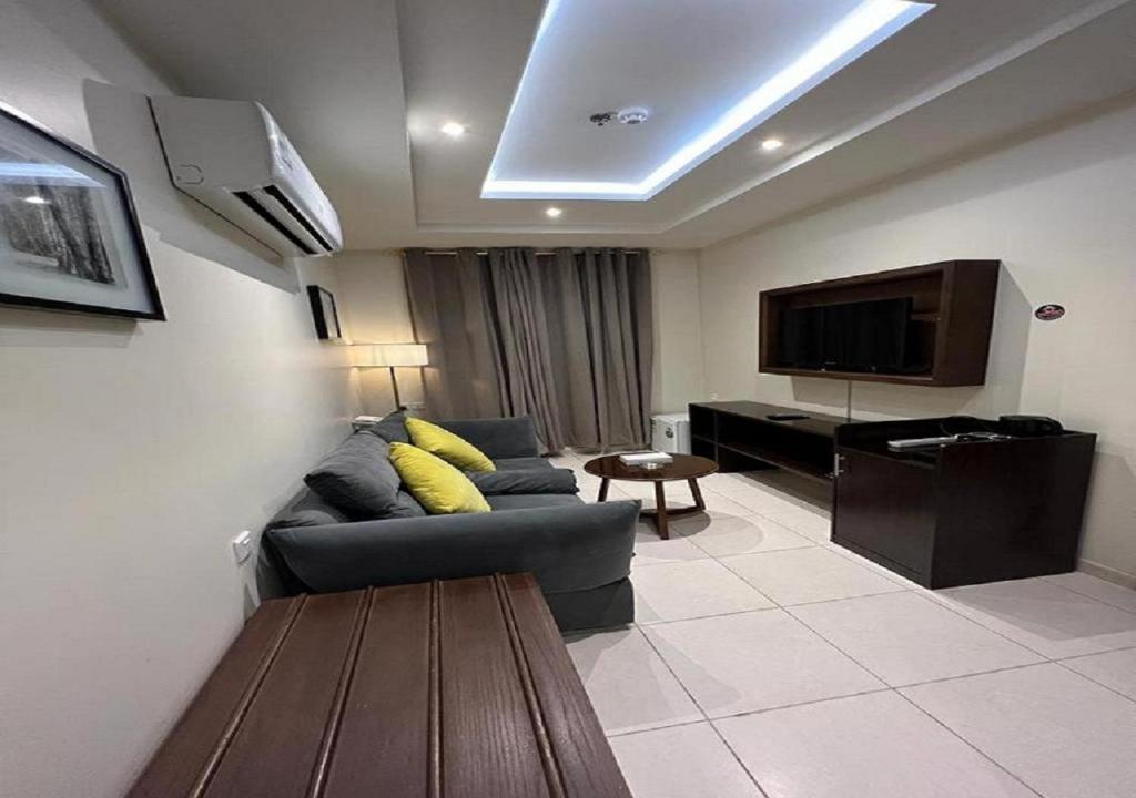 a living room with a couch and a flat screen tv at نجمة الحمراء in Jeddah