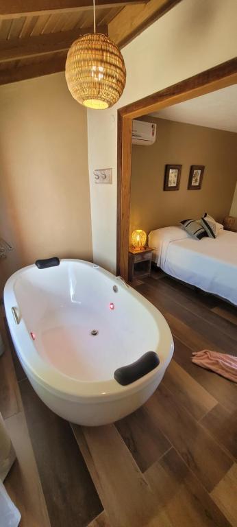 a bath tub in a room with a bedroom at Pousada Capitão Cook in Praia do Rosa