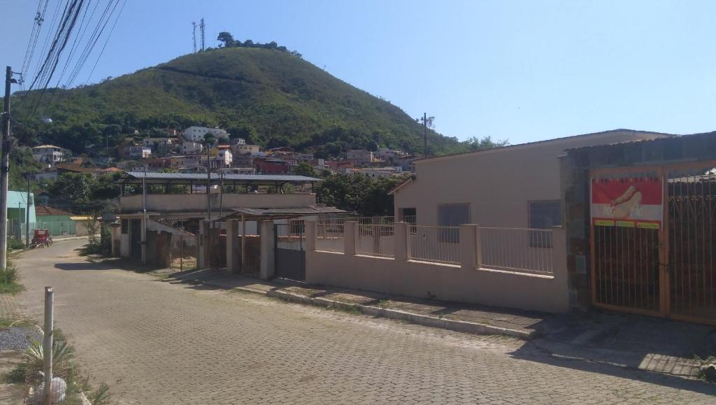 a street in a town with a mountain in the background at Hostel Meu Cantinho Caxambu Mg in Caxambu